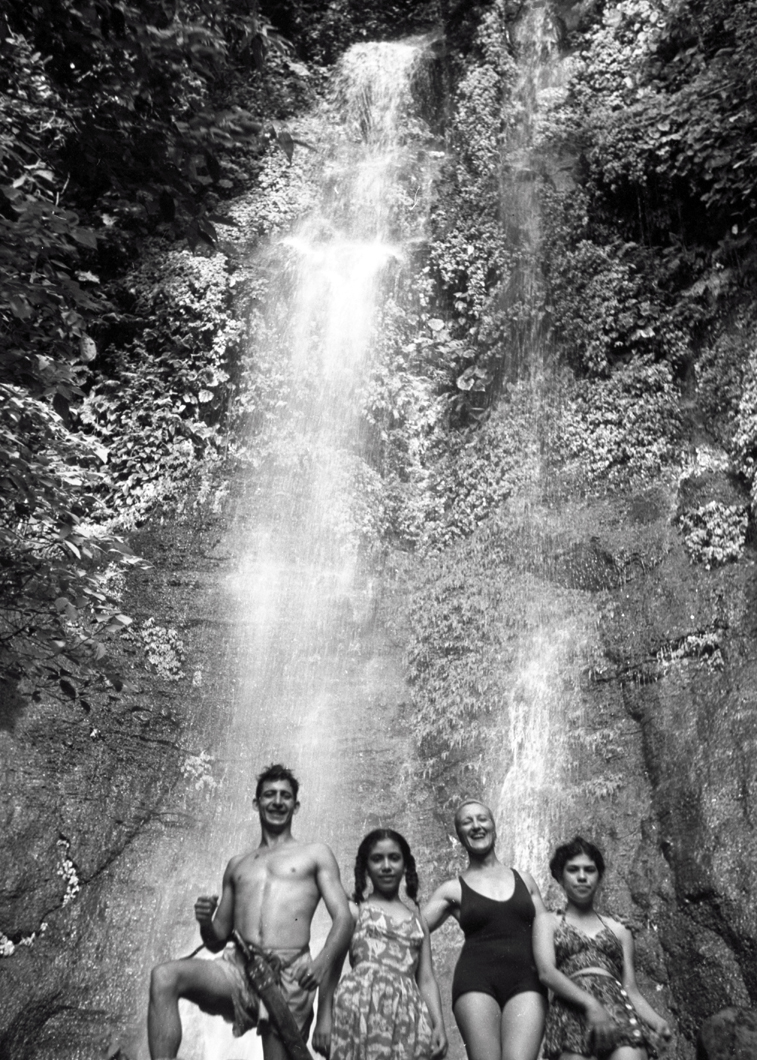 Esperanza Lopez Mateos with children in front of a jungle waterfall
