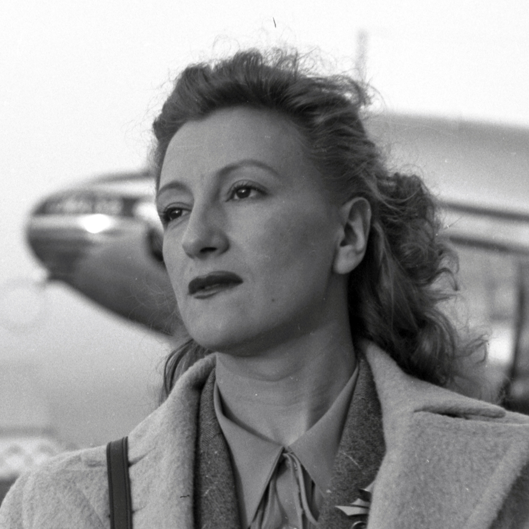 Esperanza Lopez Mateos at the airport runway with books dressed for travel