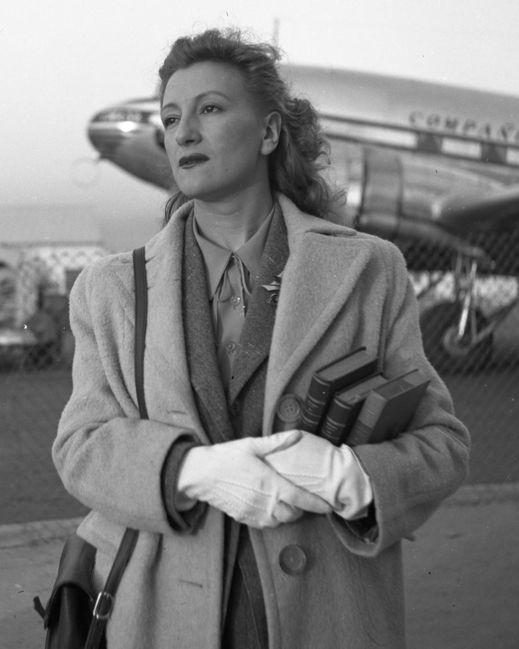 Esperanza Lopez Mateos at airport holding books